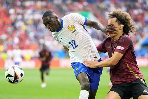 Randal Kolo Muani fights for the ball with Wout Faes